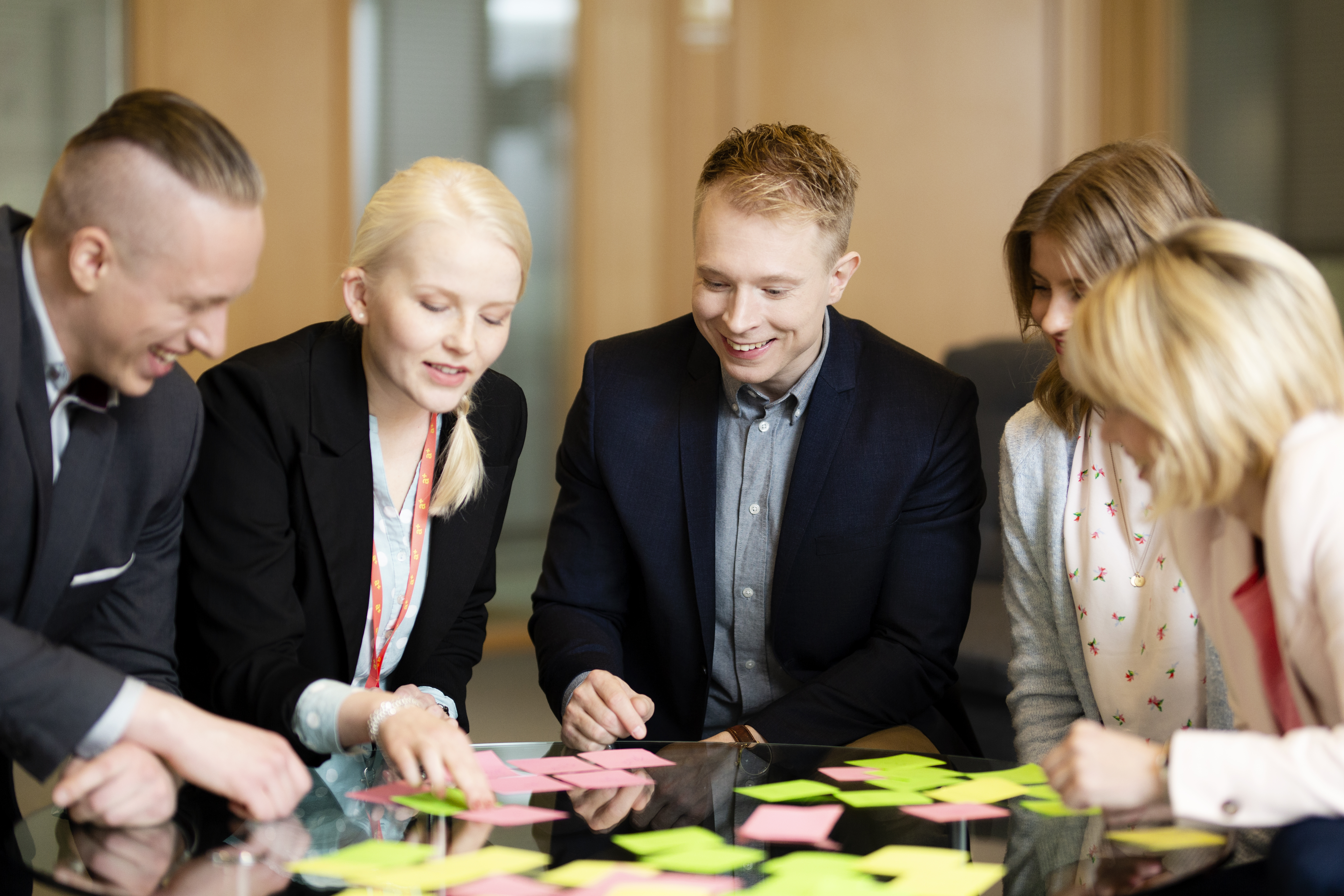 Mennesker som står over et bord med post-it-lapper