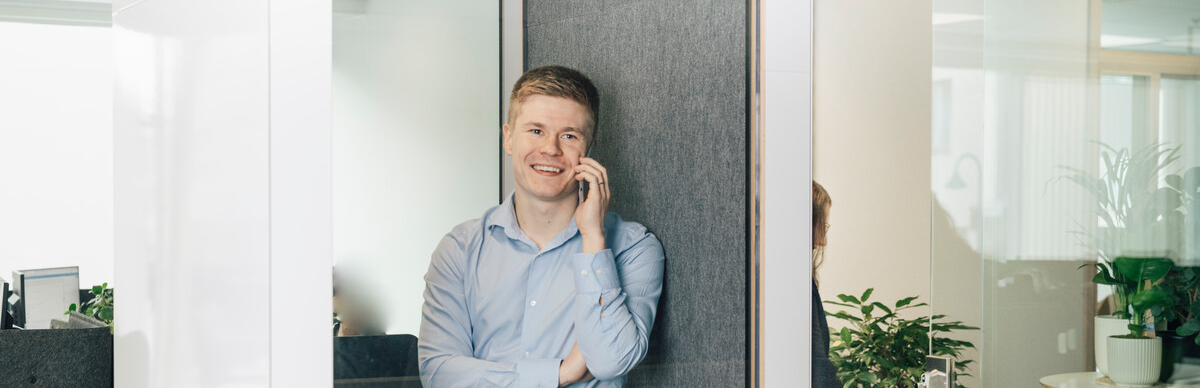 Man som prater i telefonen i en lydtett telefoncelle i åpent landskap