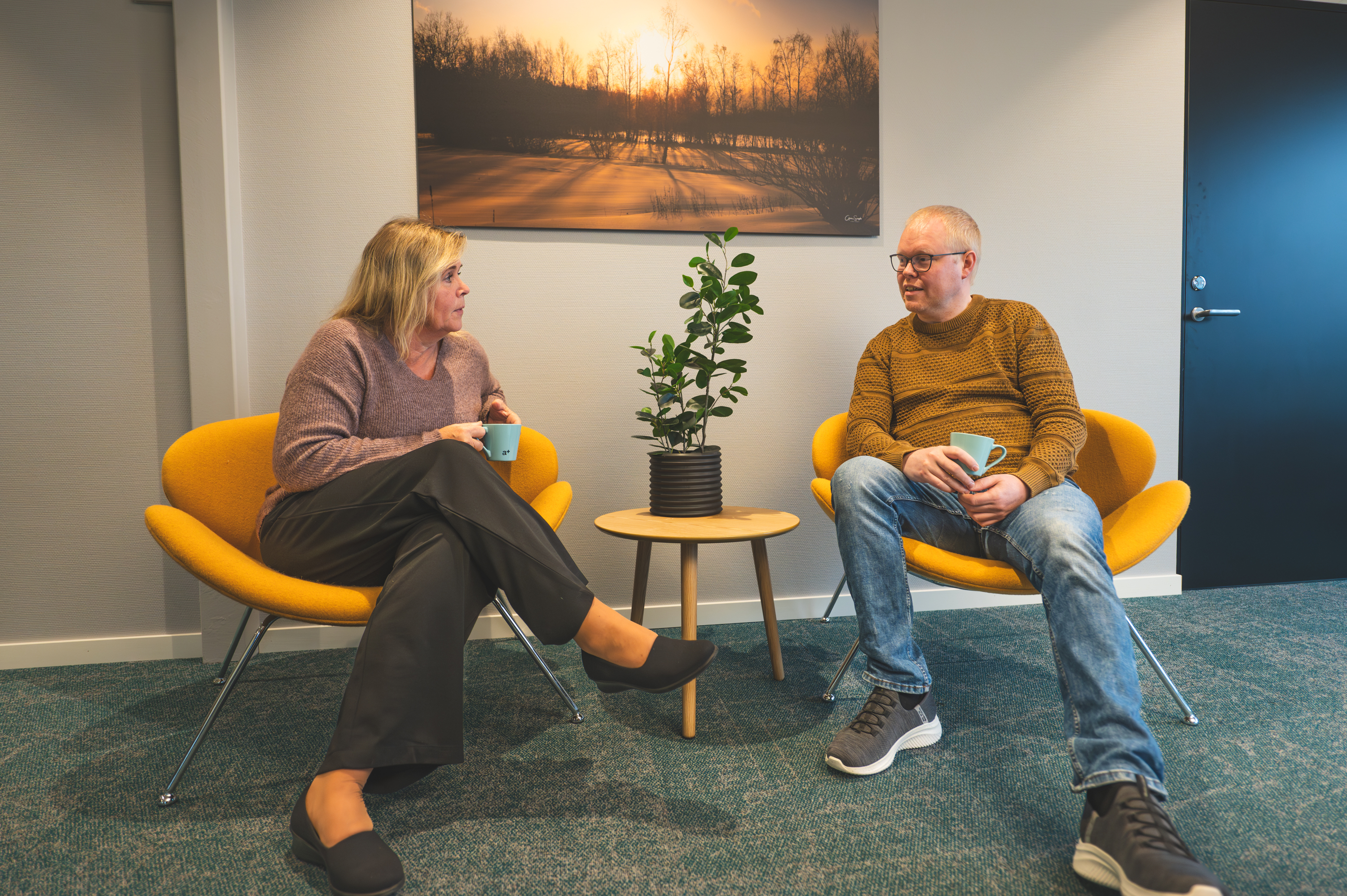 to kolleger som sitter og prater over en kopp kaffe