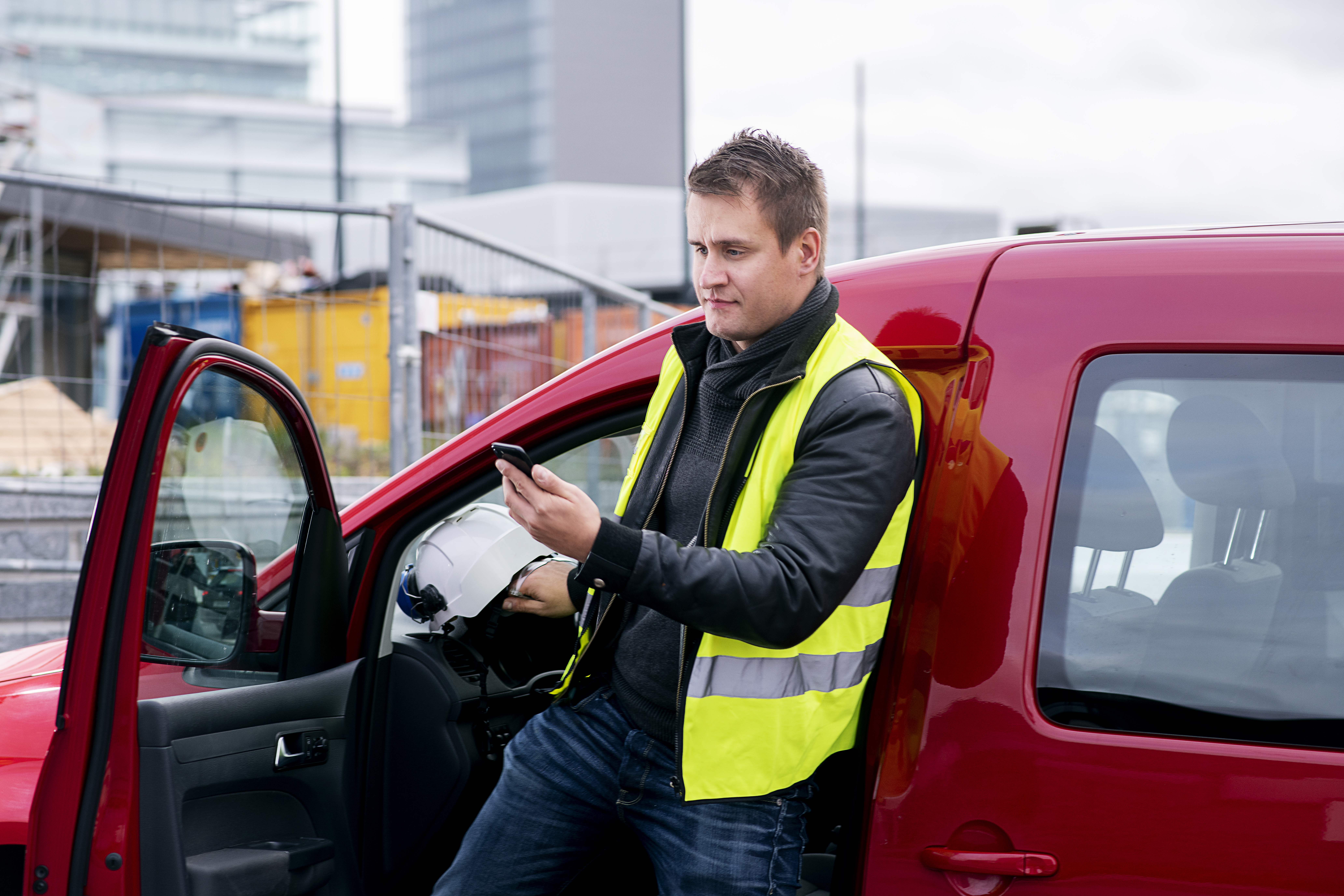 Man på telefon ved siden av bil