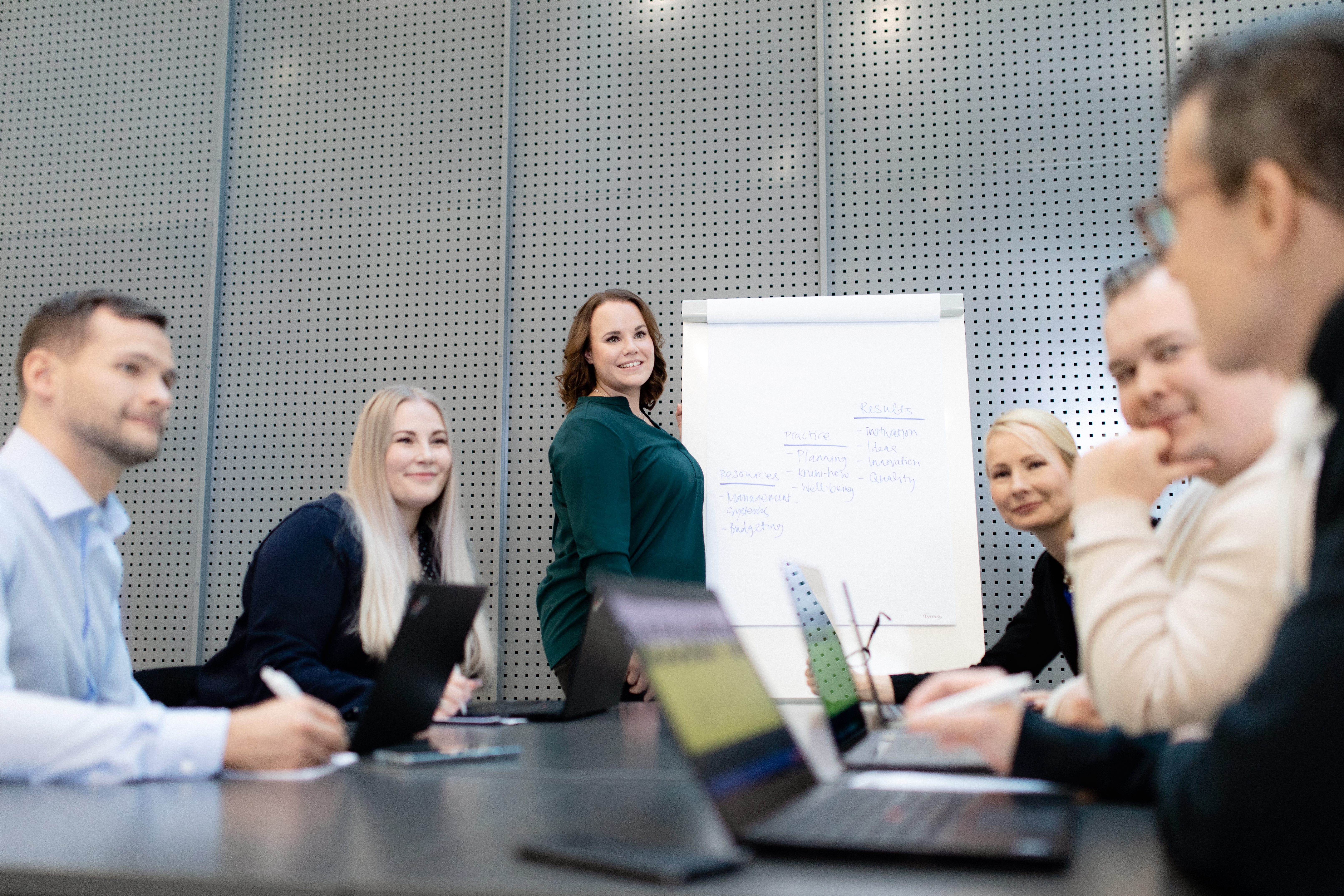 Møte med like mange kvinner og menn. En av kvinnene leder møtet.